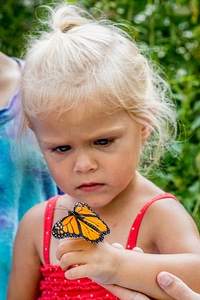 Little girl with monarch on hand