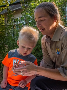 FWS employee and child look at monarch
