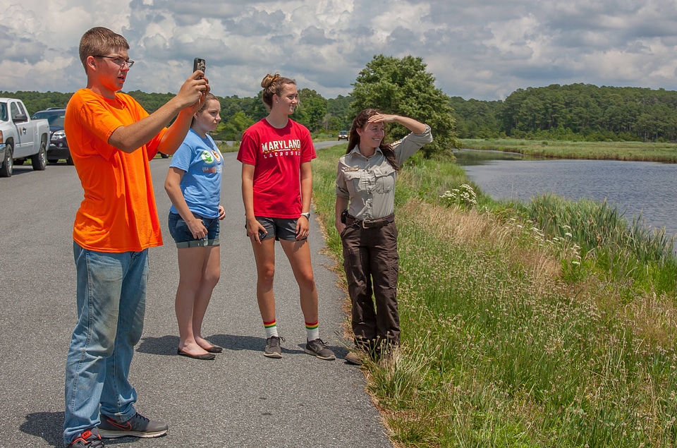 FWS staff with students taking cell phone pictures at wetland-1