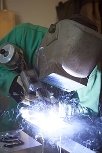 Service employee welds cages