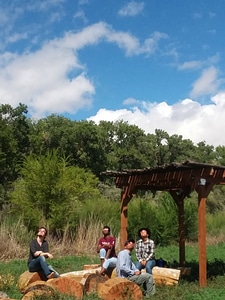 Group sits at Valle de Oro's outdoor classroom to watch the solar eclipse
