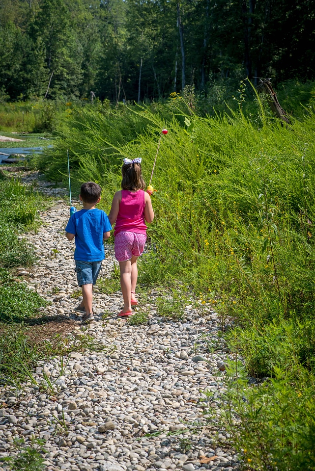 Little boy and girl going fishing, walking along creek-1