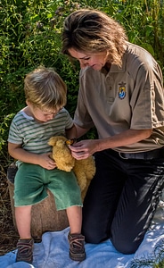 FWS employee and child look at tagged monarch on stuffed bear