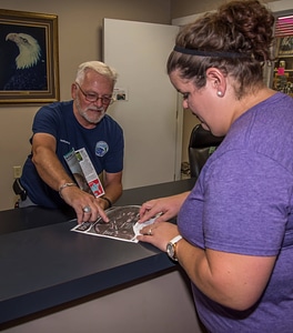 Volunteer assisting visitor at gift shop