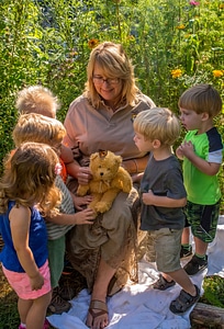 Children with fws employee look at monarch on stuffed bear