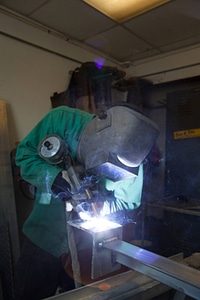 Service employee welds cages-3
