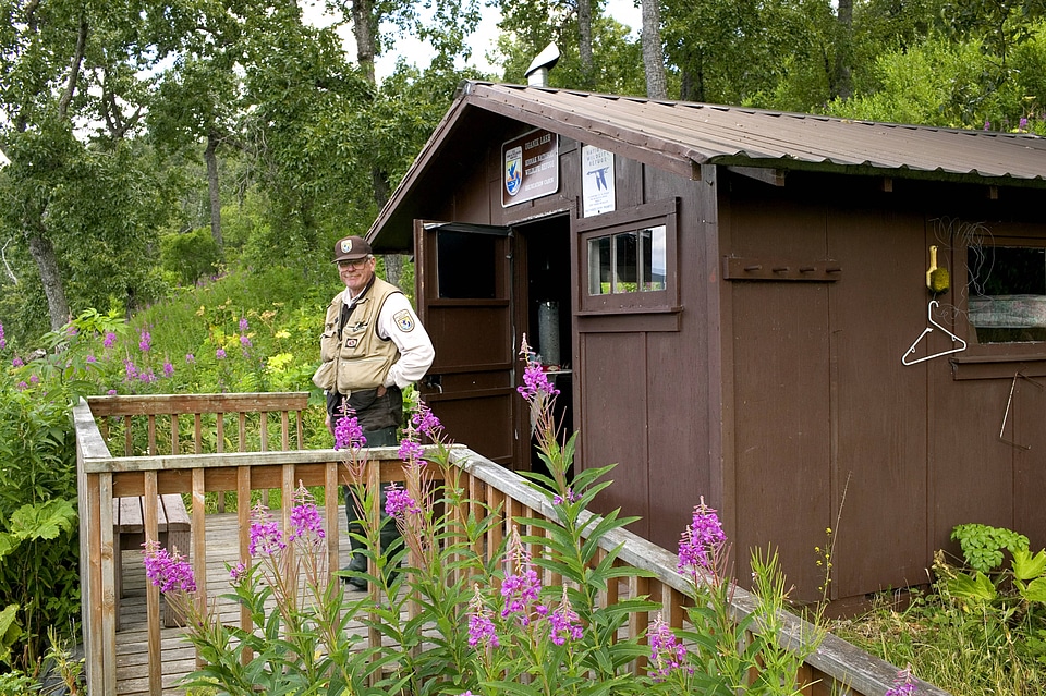 Service employee in front of Kodiak National Wildlife Refuge recreation cabin located at Uganik Lake