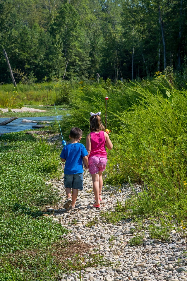 Little boy and girl going fishing, walking along creek-1