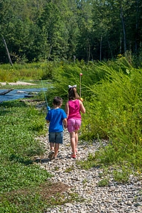 Little boy and girl going fishing, walking along creek-1