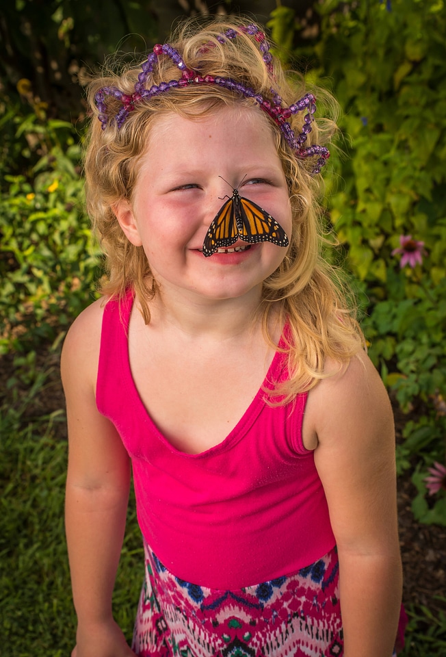 Monarch butterfly on little girl's nose