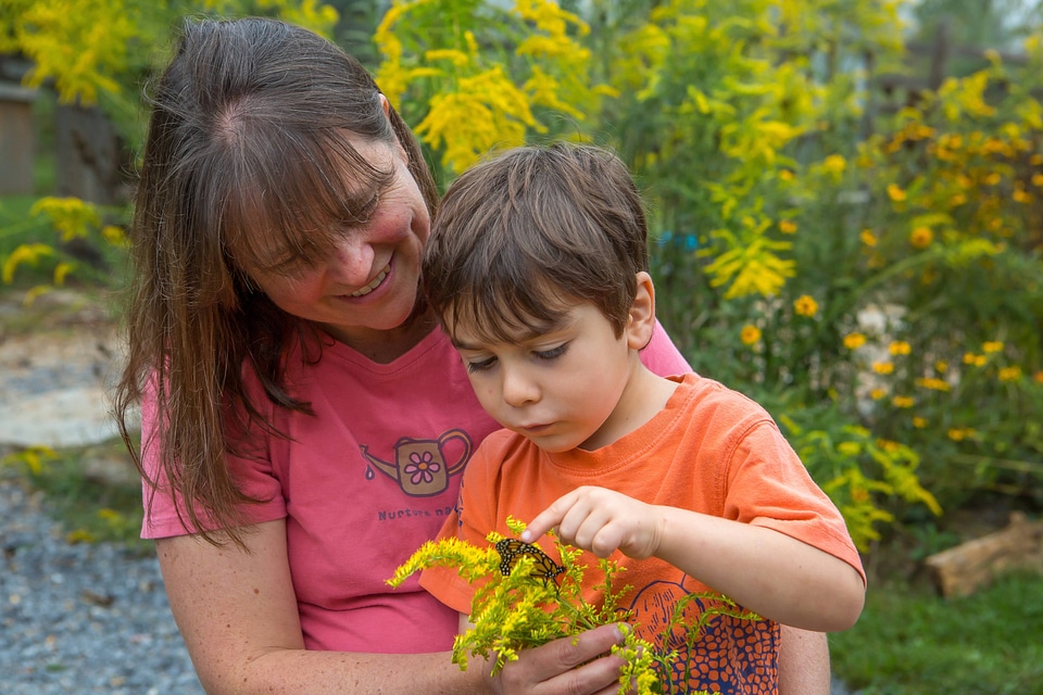Mother and son with monarch butterfly on goldenrod flowers-3
