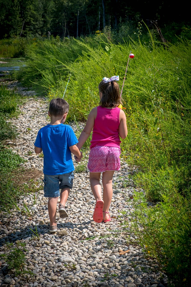 Little boy and girl going fishing, walking along creek-1