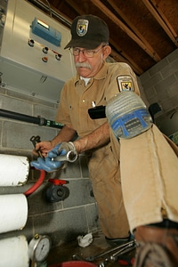 U.S. Fish and Wildlife Service employee works on pump