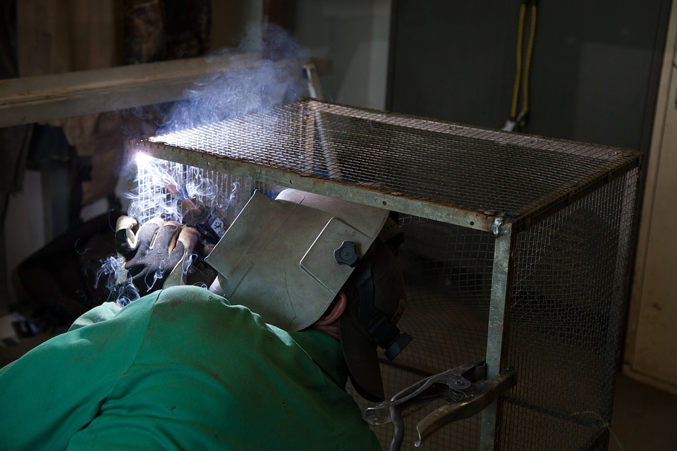Service employee welds cages-2