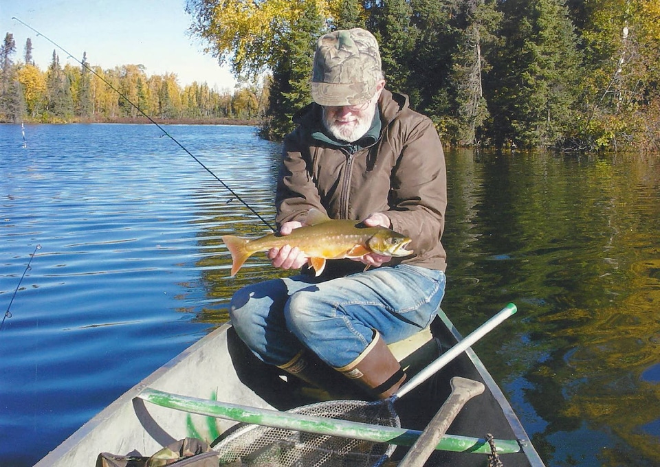 Fisherman catches an Arctic char