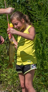 Little girl catching brown trout photo