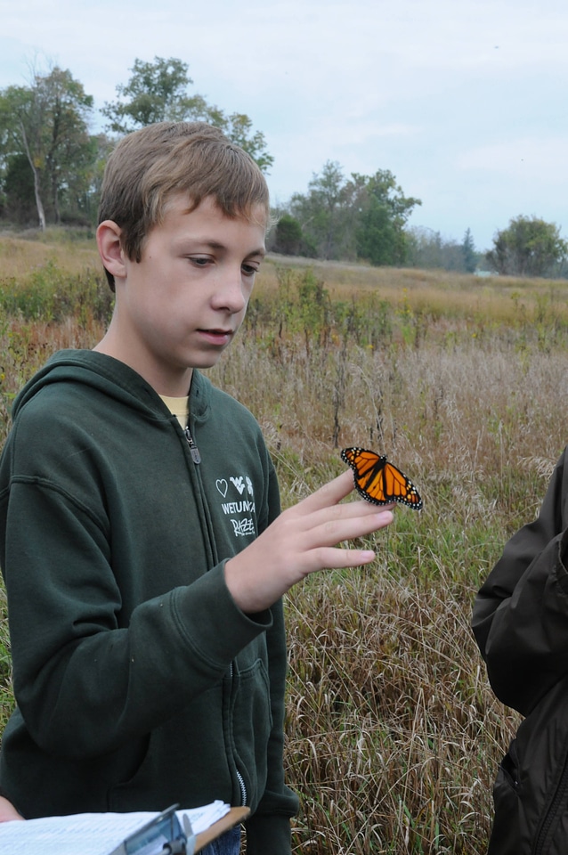 Boy holds Monarch butterfly