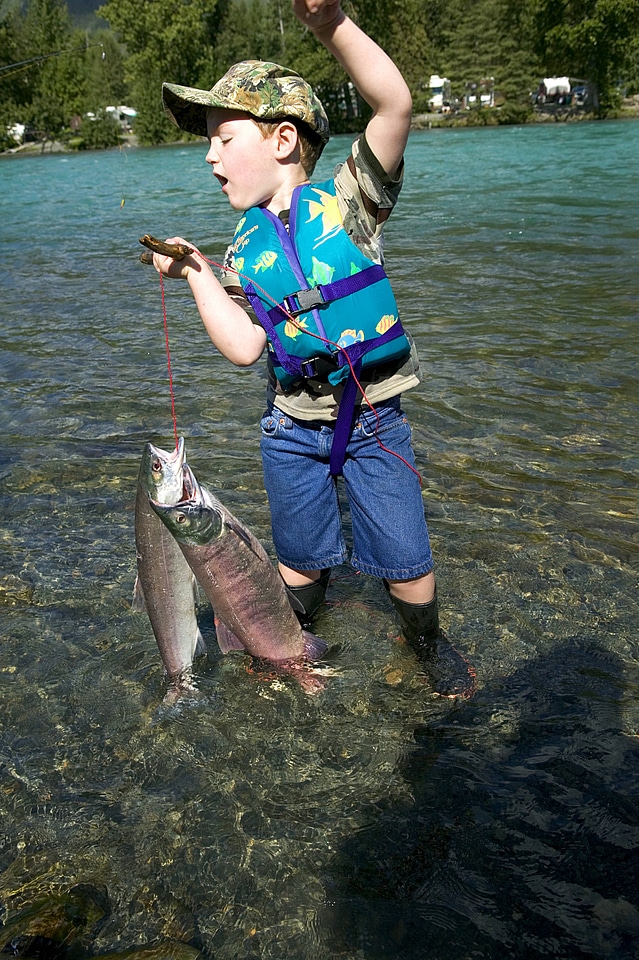 Young boy struggles to hold the fish stringer
