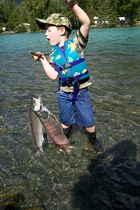 Young boy struggles to hold the fish stringer photo