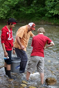 Educator and students collecting macroinvertebrates