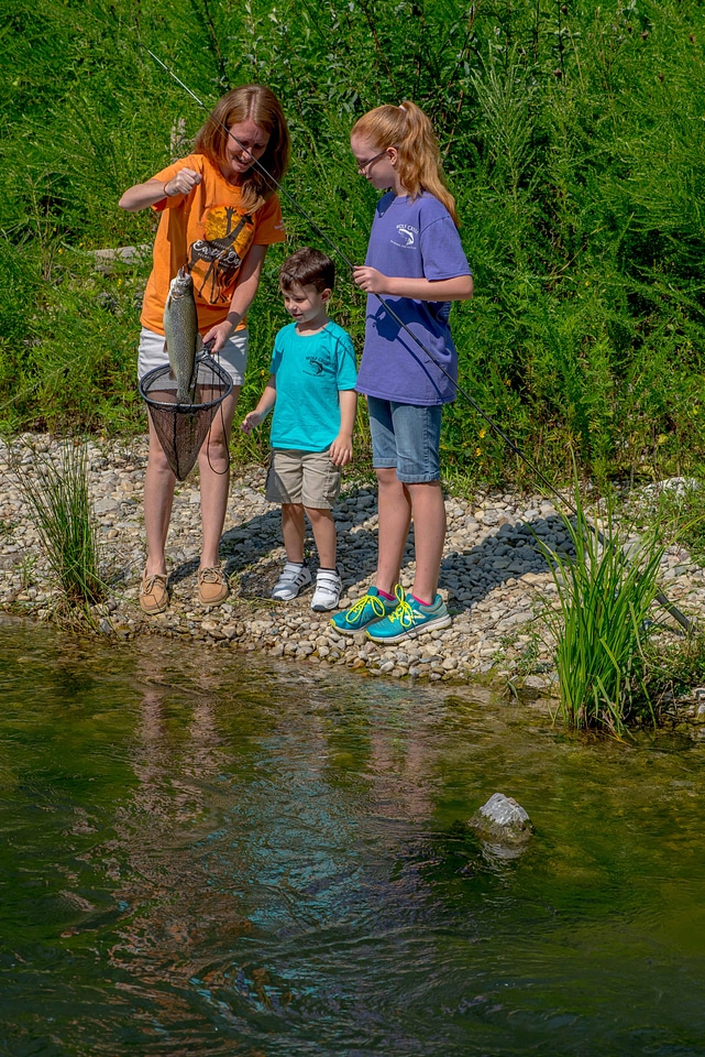 Family fishing, mother nets rainbow trout-3