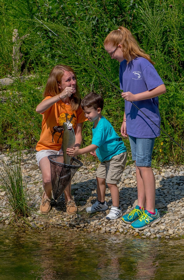Family fishing, mother nets rainbow trout-1