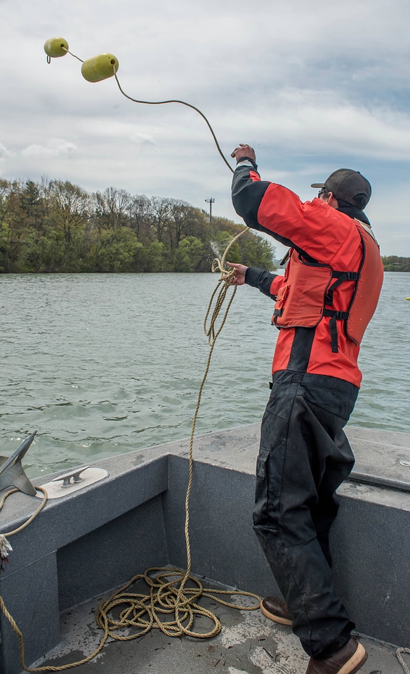 USFWS Fisheries worker thowing out buoys-1