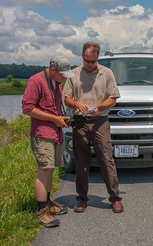 Staff talks to young birdwatcher at truck