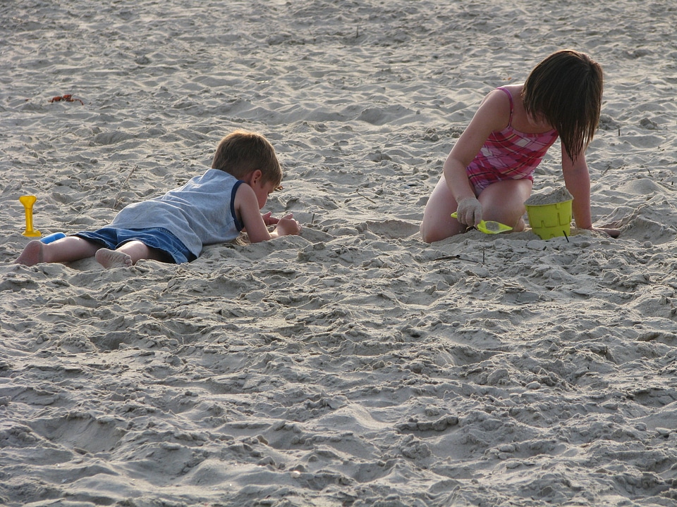 Two children playing in the sand