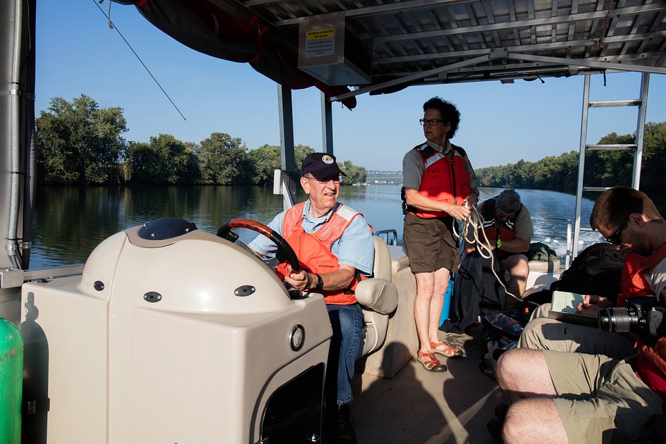 Volunteer, Richard Esker, drives a boat on the Ohio River