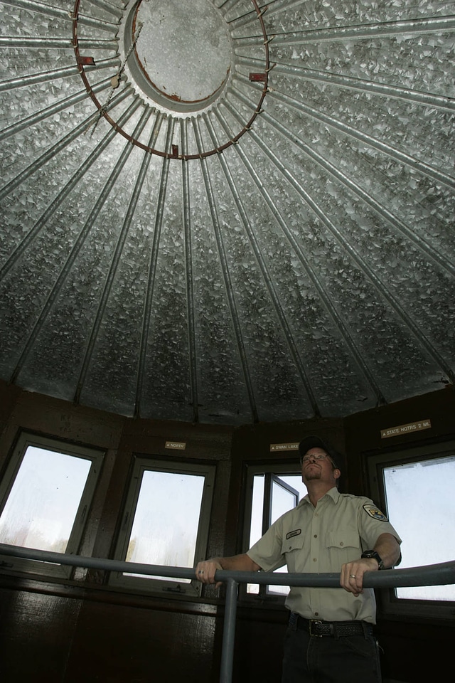 FWS employee examining inside roof of observation tower