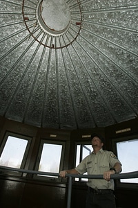 FWS employee examining inside roof of observation tower photo
