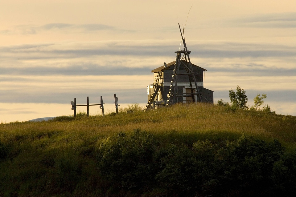 Wooden structure and fence on a hill in Alaska