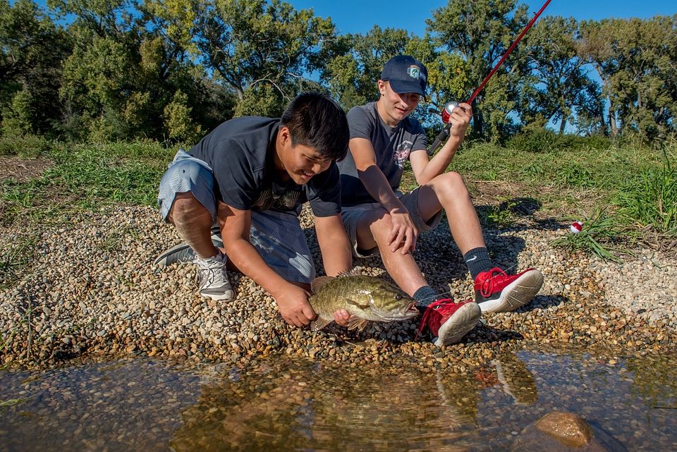 Two boys releasing small mouth bass-3