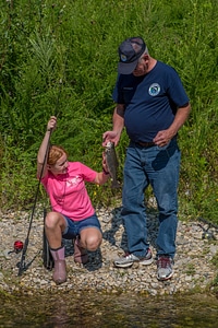 Older man with young redheaded girl and rainbow trout-4