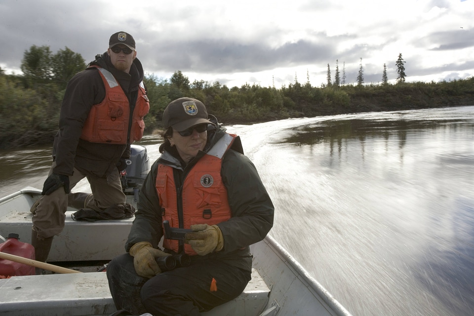 U.S. Fish and Wildlife Service personnel navigating a boat in Alaska
