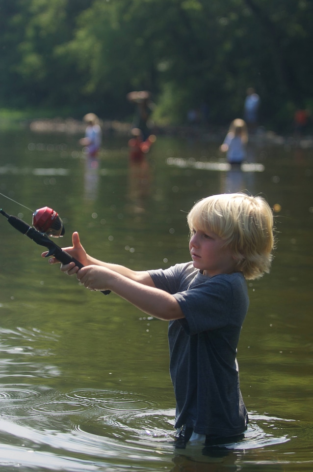 Young boy with his fishing line cast into the water