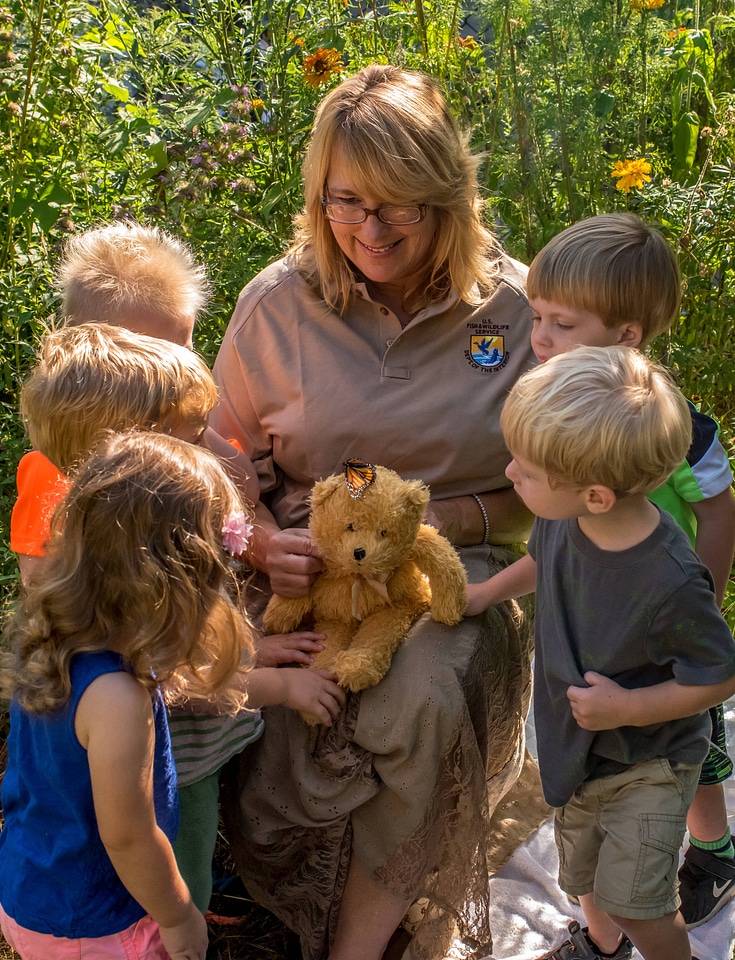Children with fws employee look at monarch on stuffed bear-1