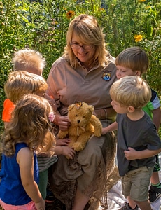 Children with fws employee look at monarch on stuffed bear-1