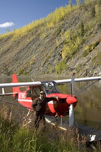 U.S. Fish and Wildlife Service pilot poses beside a seaplane photo