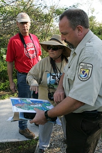Service employee assisting visitors with refuge map photo