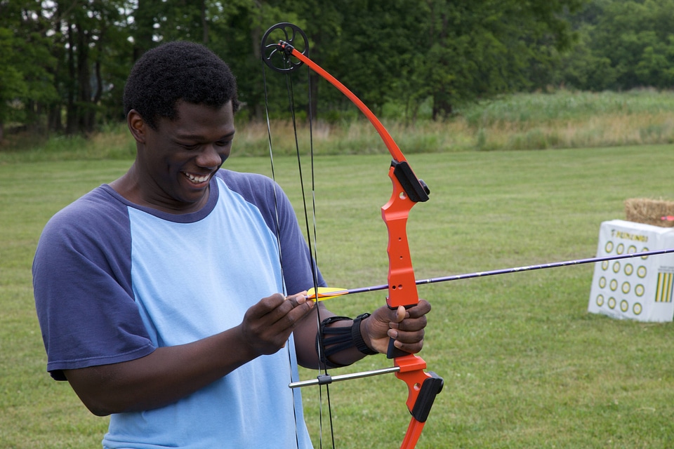 Youth is preparing to shoot a bow and arrow