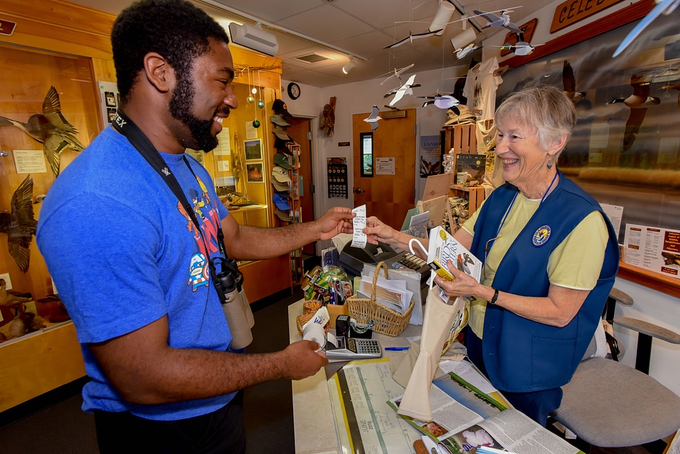 FWS volunteer with visitor in gift shop-1