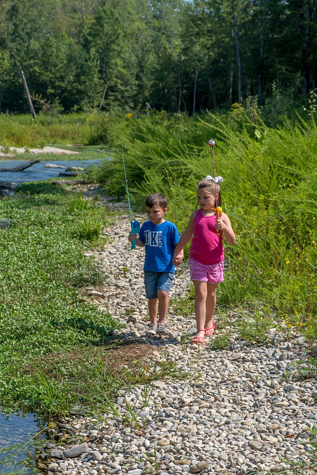 Little boy and girl going fishing, walking along creek-1