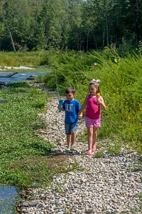 Little boy and girl going fishing, walking along creek-1