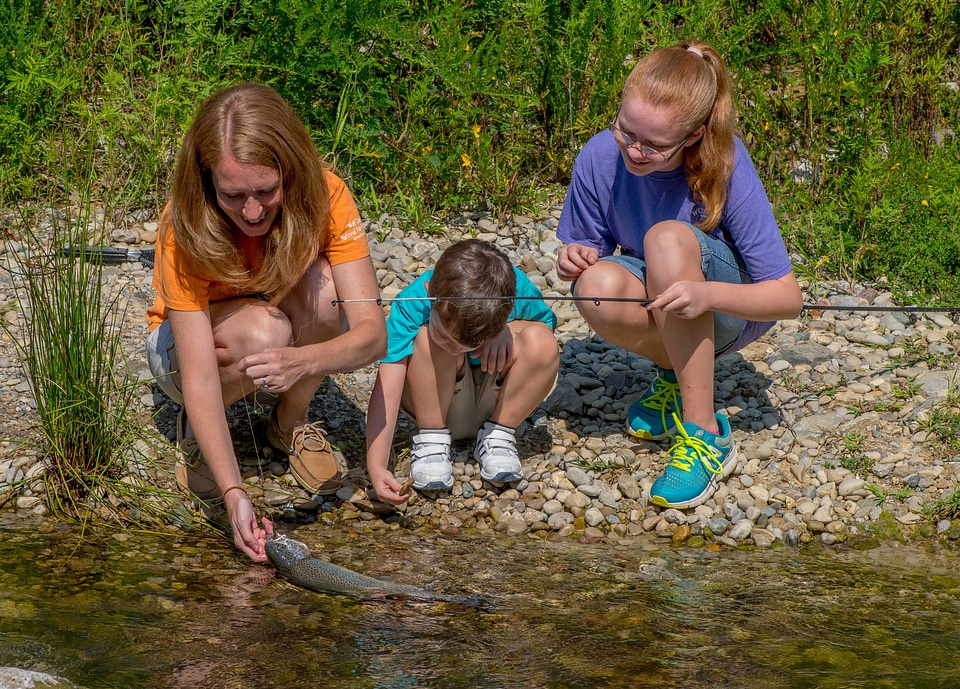 Family fishing, mother nets rainbow trout-3