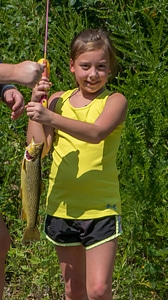 Little girl catching brown trout-2 photo