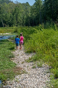 Little boy and girl going fishing, walking along creek-1