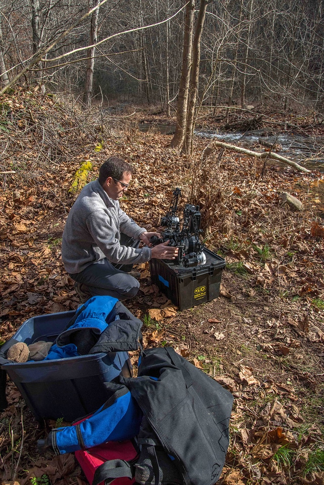 Photographer checking over camera equipment before dive