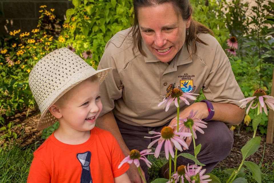 FWS employee with little boy look at monarch on flower